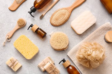 Hafif arka planda fırça ve süngerli banyo malzemeleri.