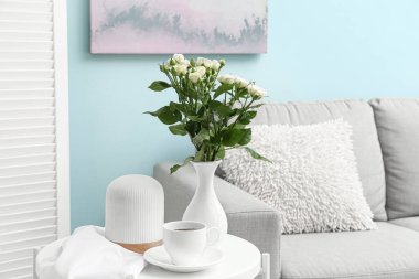 Güzel bir gül buketi, difüzör ve kahve dolu bir vazo.