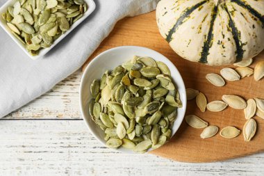 Beyaz ahşap zemin üzerinde kabak tohumları kaseleri