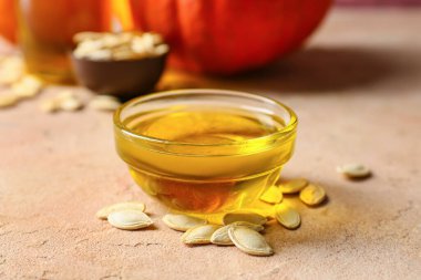 Bej arka planda balkabağı tohumu yağı ile kase