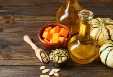 Tahta arka planda balkabağı tohumu yağlı sürahiler