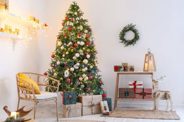 Noel ağacı, sandalye ve raf aydınlık duvarın yanında.