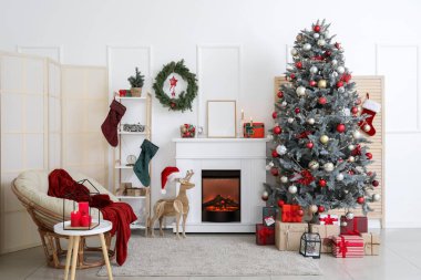 Güzel bir Noel ağacı ve şöminesi olan dekore edilmiş bir oturma odası.