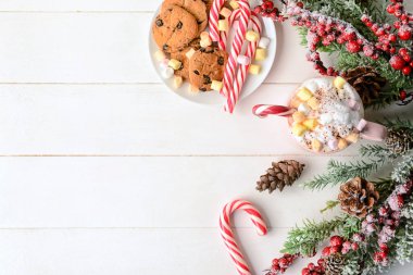 Beyaz ahşap arka planda lokum ve baston şekerli bir fincan lezzetli kakao.