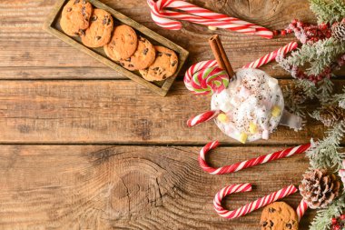 Bir fincan lezzetli kakao, marşmelov ve tahta arka planda şeker kamışı.