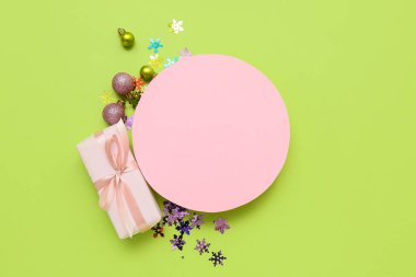 Boş kartlı kompozisyon, Noel süslemeleri ve yeşil arka planda hediye kutusu