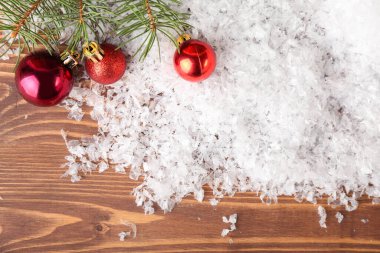 Noel baloları, kar ve köknar dalları ahşap arka planda
