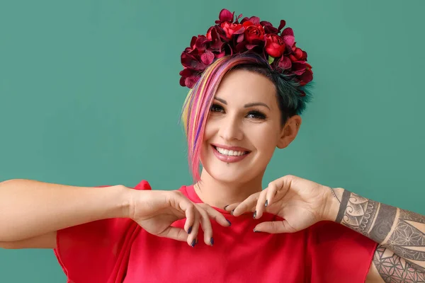色の背景に異常な髪と花の花輪を持つ美しい女性 — ストック写真