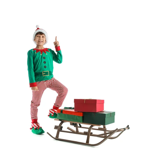 Kleiner Junge Elfenkostüm Mit Schlitten Und Weihnachtsgeschenken Auf Weißem Hintergrund — Stockfoto