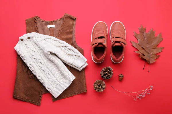Babybekleidung Schuhe Und Natürliches Walddekor Auf Rotem Hintergrund — Stockfoto