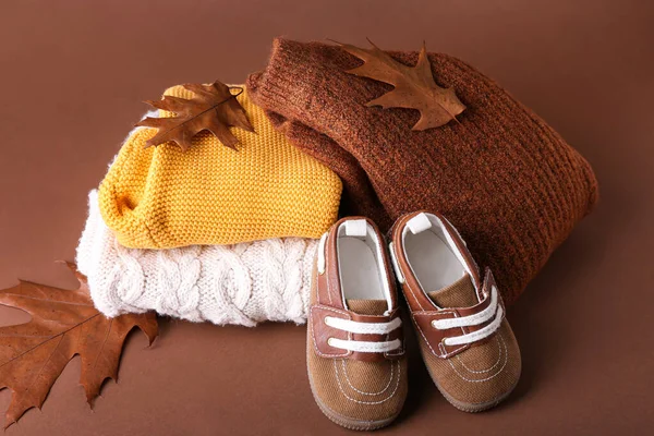五彩斑斓的婴儿衣服 鞋子和秋天的树叶堆积如山 — 图库照片