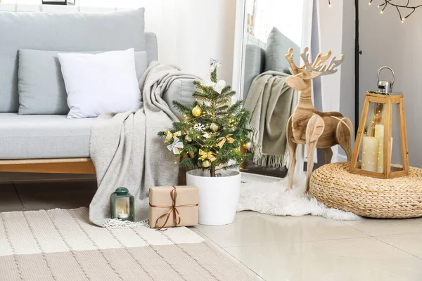 リビングルームで小さなクリスマスツリーとグレーのソファ — ストック写真