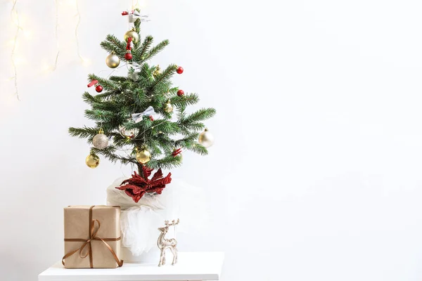Árvore Natal Pequena Com Presente Mesa Perto Parede Clara — Fotografia de Stock