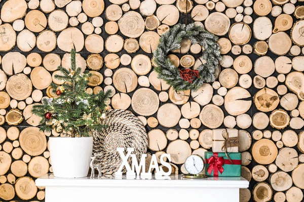 プレゼント 目覚まし時計と木製の壁の近くのマントルピースの装飾を持つ小さなクリスマスツリー — ストック写真