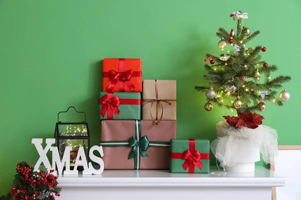 Pequeño Árbol Navidad Con Regalos Repisa Cerca Pared Verde —  Fotos de Stock