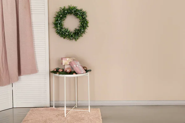 Christmas Gift Boxes Table Beautiful Wreath Mistletoe Hanging Beige Wall — Stock Photo, Image