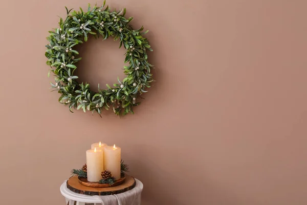 Burning Candles Table Beautiful Wreath Mistletoe Hanging Brown Wall — Stock Photo, Image