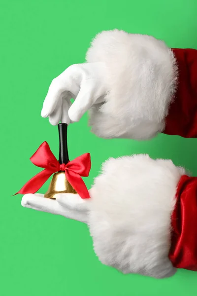 Weihnachtsmann Hände Mit Weihnachtsglocke Auf Grünem Hintergrund Nahaufnahme — Stockfoto