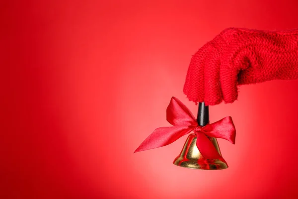 Female Hand Knitted Glove Christmas Bell Red Background Closeup — Stock Photo, Image