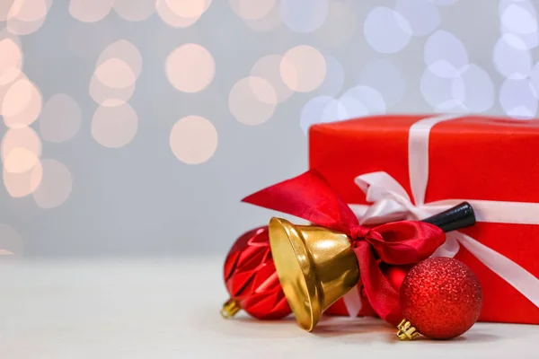 Christmas Bell Red Ribbon Gift Box Balls Table Blurred Lights — Stock Photo, Image