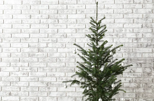Mooie Versierde Kerstboom Buurt Van Lichte Bakstenen Muur Close — Stockfoto