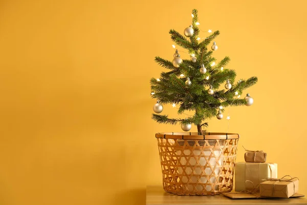 Süslü Noel Ağacı Saksıda Hediye Kutuları Sarı Duvarın Yanında — Stok fotoğraf