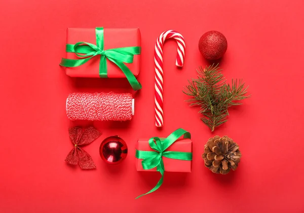 Komposition Mit Weihnachtsgeschenken Dekorationen Und Seil Auf Rotem Hintergrund — Stockfoto