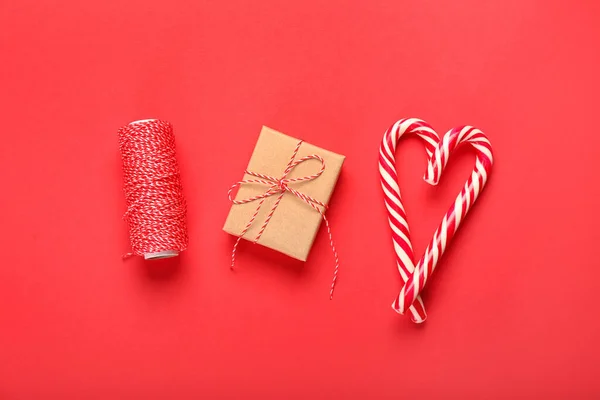 クリスマスプレゼント キャンディーキャンディーとロープで作られた心は赤い背景 — ストック写真