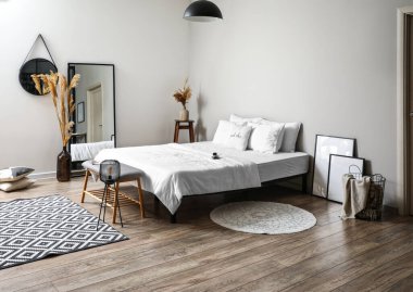 Banklı yatak odası, rahat yatak ve şık ayna.