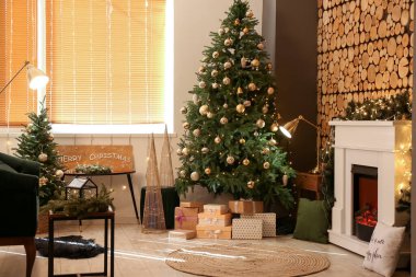 Noel ağacı ve süslü şömineli şık bir iç mekan.