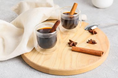 Hafif arka planda tarçınlı bir bardak lezzetli kahve.