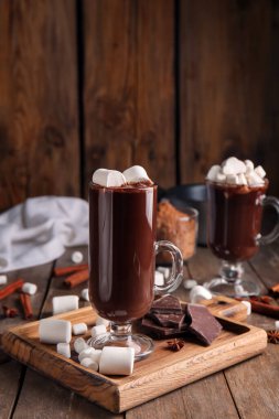 Ahşap zemin üzerinde lokum bulunan bir bardak lezzetli sıcak çikolata.