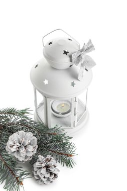 Güzel Noel feneri yanan mum, köknar dalı ve beyaz arka planda çam kozalakları