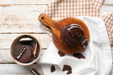 Hafif ahşap arka planda kremalı lezzetli çikolatalı kurabiyeler.