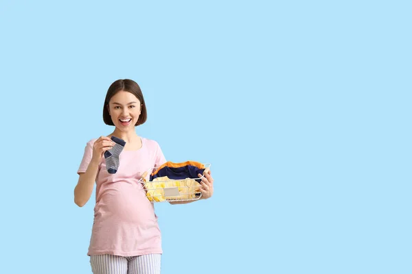 Ung Gravid Kvinna Med Baby Strumpor Och Kläder Blå Bakgrund — Stockfoto