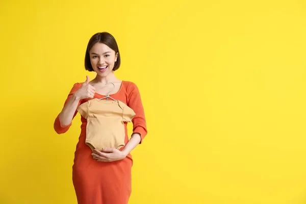 Young Pregnant Woman Baby Bodysuit Showing Thumb Yellow Background — Stock Photo, Image