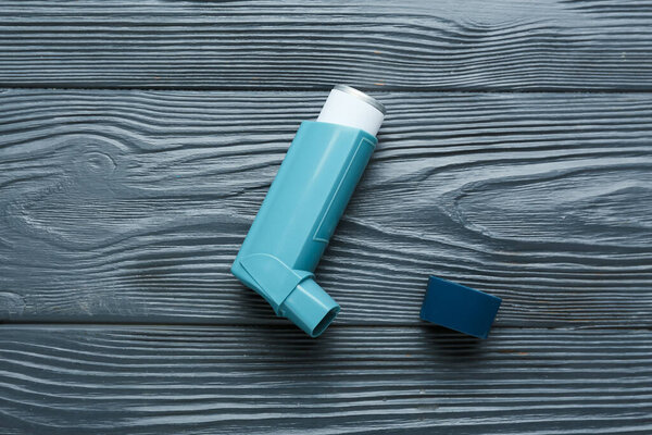 Ингалятор астмы на темном деревянном фоне