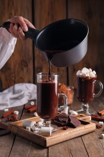 Frau Gießt Heiße Schokolade Aus Topf Glasschale Auf Holzgrund — Stockfoto