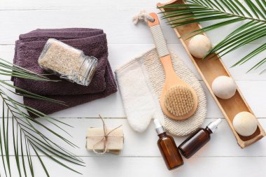 Hafif ahşap arka planda gerekli yağ şişeleriyle spa seti