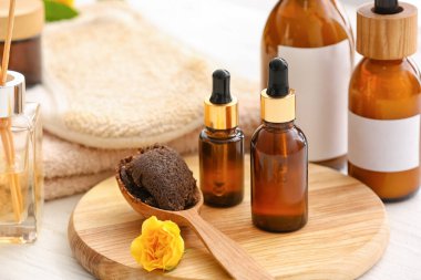 Hafif ahşap arka planda gerekli yağ şişeleriyle spa seti