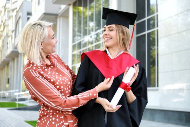 Mezuniyet gününde annesi ile mutlu genç kadın