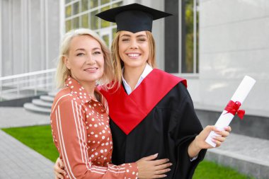 Mezuniyet gününde annesi ile mutlu genç kadın