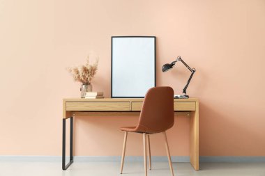 Renk duvarının yanında boş posteri olan şık bir iş yeri