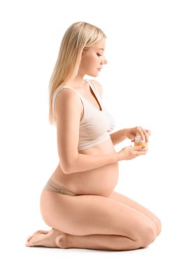 Beyaz arka planda kozmetik kremi olan güzel hamile kadın.