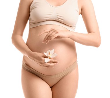 Beyaz arka planda orkide çiçeği olan güzel hamile bir kadın.