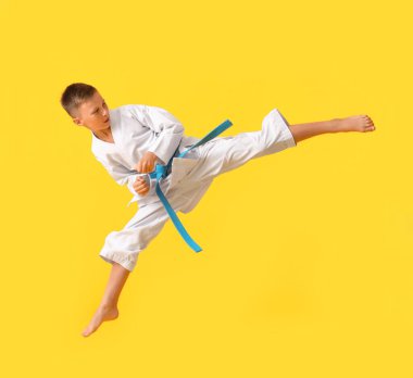 Küçük çocuk renkli arka planda karate yapıyor.