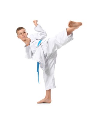 Küçük çocuk beyaz arka planda karate yapıyor.