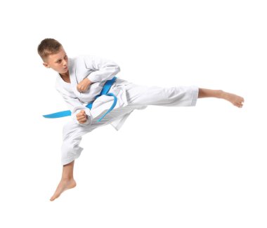 Küçük çocuk beyaz arka planda karate yapıyor.