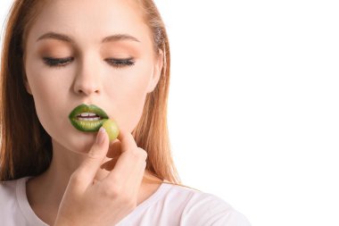 Beyaz arka planda olağandışı makyajı ve üzümü olan güzel genç bir kadın.