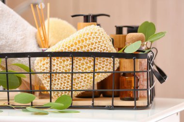 Masada banyo süngeri, şişe ve okaliptüs dalı olan sepet, yakın plan.